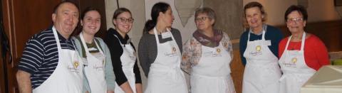 Mehrere Gastgebende mit Vesperkirche-Schürzen