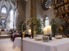 Der Abendmahlstisch im Abschlussgottesdienst. Im Hintergrund sitzen bereits die ersten Gäste an den Tischen.
