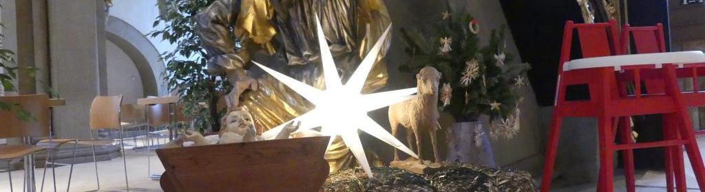 Eine kleine Krippe mit Weihnachtsstern, daneben Kinderstühle