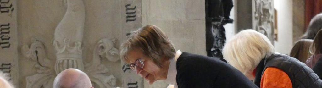 Regionalbischöfin Gisela Bornowski bedient Gäste am Tisch in der Vesperkirche