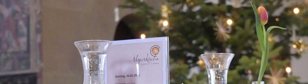 Gedeckter Tisch mit Speisekarte, im Hintergrund der Weihnachtsbaum